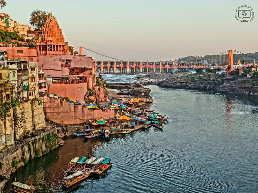 Omkareshwar Temple and River Narmada Ghat with Boats and Suspension Bridge at Dusk HD wallpaper