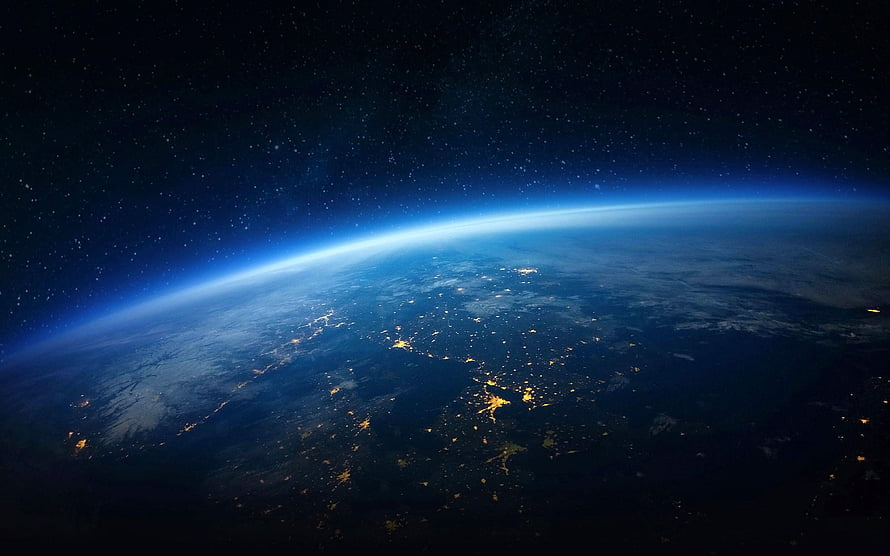 Earth at Night From Space: City Lights and Atmospheric Glow Against the Starry Cosmos HD wallpaper