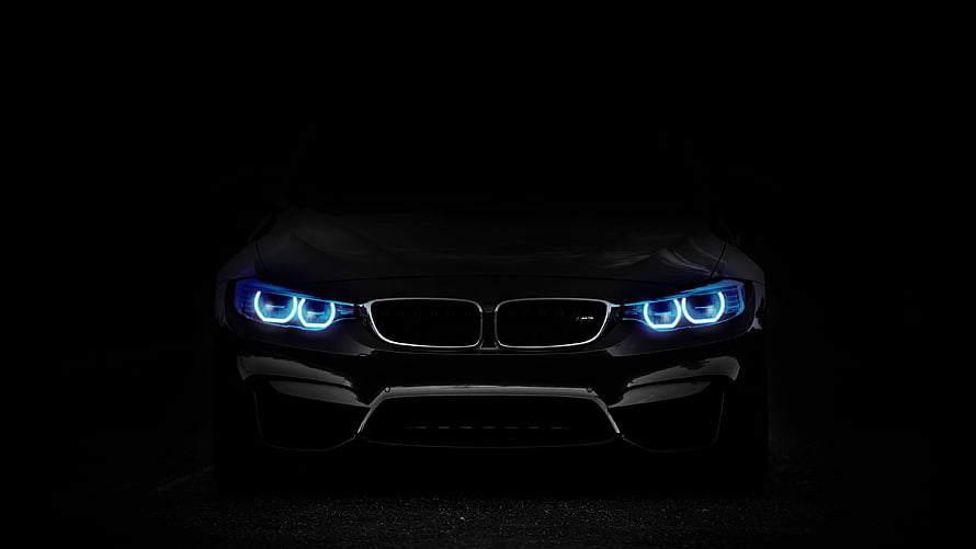 BMW M4 Front View With Glowing Blue Headlights In Dark Studio Setting HD wallpaper