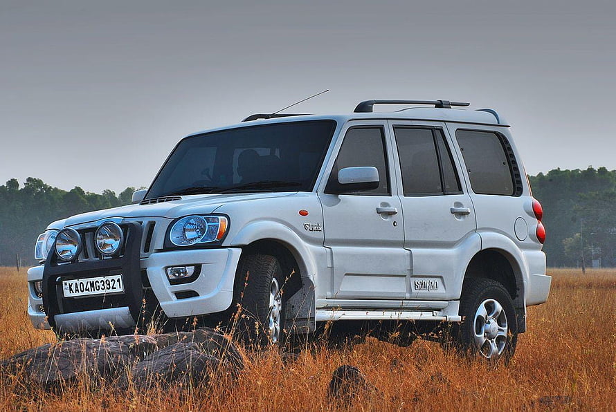 Silver Mahindra Scorpio SUV parked in a golden grassy field with a rugged front bumper and roof rack HD wallpaper