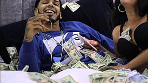 Anuel AA Surrounded by Cash and Jewelry in a Lavish Setting HD wallpaper
