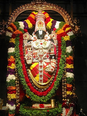 Lord Venkateswara Swamy adorned in vibrant flower garlands and ornate temple jewelry HD phone wallpaper