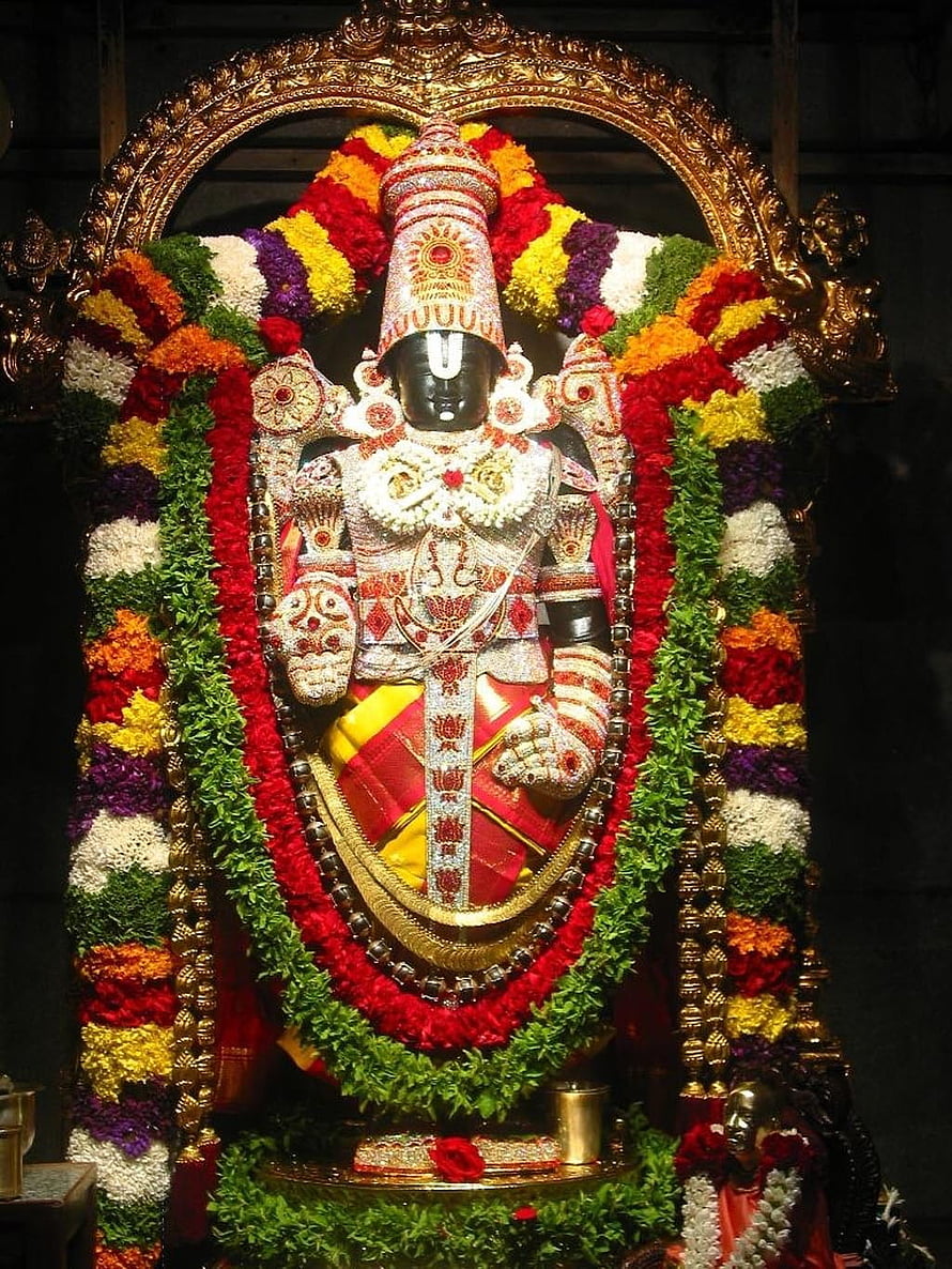 Lord Venkateswara Swamy adorned in vibrant flower garlands and ornate temple jewelry HD phone wallpaper