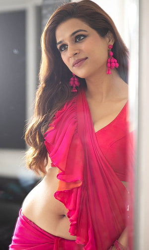 Shraddha Das in a vibrant pink ruffled saree with matching beaded earrings HD phone wallpaper