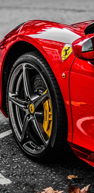 Red Ferrari Close-Up: Glossy Body, Yellow Brakes, and Iconic Prancing Horse Emblem HD phone wallpaper