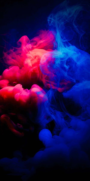 Vibrant Red and Blue Smoke Swirling Against a Dark Background HD phone wallpaper