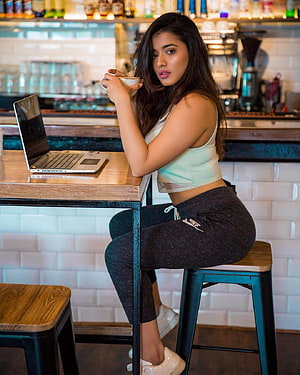 Kethika Sharma Sitting at Cafe Bar with Laptop and Coffee Cup HD phone wallpaper