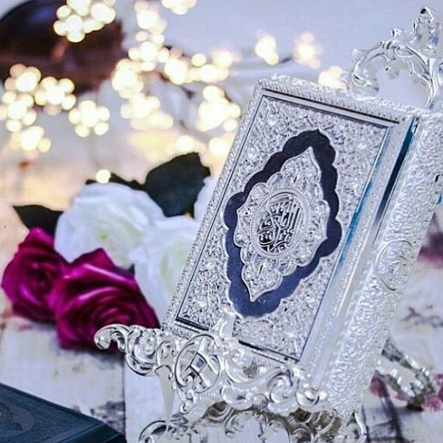 Ornate Silver Quran Stand with Intricate Engraving and Floral Arrangement HD phone wallpaper