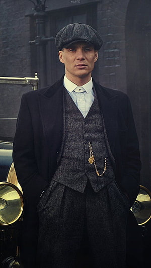 Tommy Shelby in Period Three-Piece Suit and Flat Cap Standing Before Vintage Car HD phone wallpaper