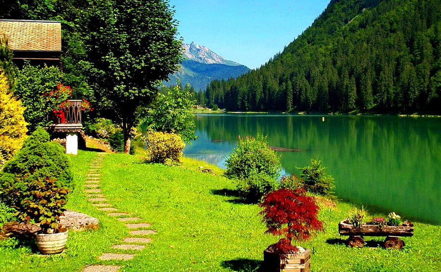 Serene Alpine Lake View With Lush Garden Path And Mountain Reflections HD wallpaper