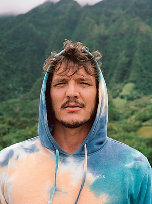 Pedro Pascal Wearing a Tie-Dye Hoodie Against a Lush Mountain Backdrop HD phone wallpaper