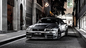 Nissan Skyline GT-R R34 parked on a dimly lit urban street at night HD wallpaper