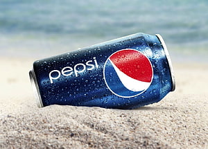 Chilled Pepsi Can Resting on Sandy Beach with Ocean Waves in Background HD wallpaper