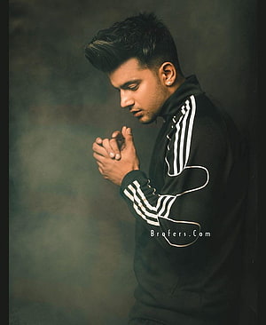 Jass Manak in a black track jacket with hands clasped in a moody studio portrait HD phone wallpaper