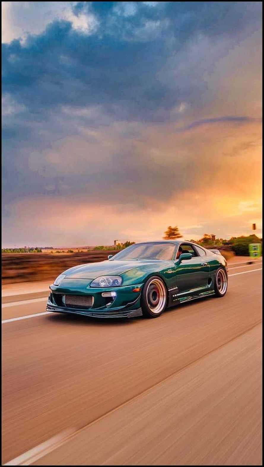 Green Toyota Supra MK4 Cruising on Highway at Sunset with Dramatic Clouds HD phone wallpaper