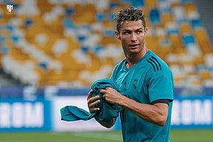 Cristiano Ronaldo in Real Madrid Training Kit Holding Jersey on Pitch HD wallpaper