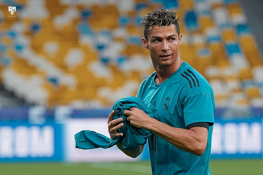Cristiano Ronaldo in Real Madrid Training Kit Holding Jersey on Pitch HD wallpaper