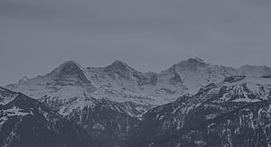 Majestic Snow-Capped Mountain Range Under Overcast Winter Sky HD wallpaper