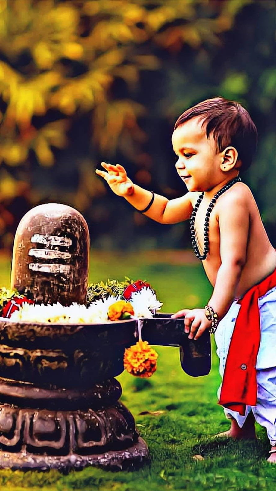 Young Child Offering Flowers to a Shivling in a Garden Setting HD phone wallpaper