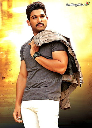 Allu Arjun in a grey t-shirt and white trousers with a jacket over his shoulder HD phone wallpaper