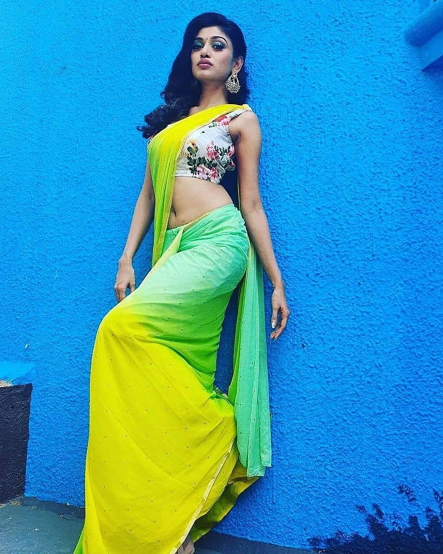 Oviya Helen in Vibrant Green Saree with Floral Blouse Against Blue Wall HD phone wallpaper