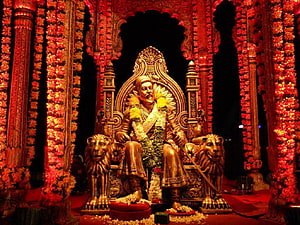 Chhatrapati Shivaji Maharaj Rajyabhishek Statue with Lion Guardians and Floral Decorations HD wallpaper