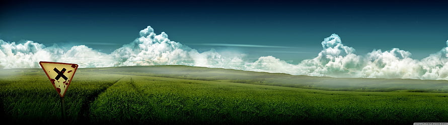 Vast Green Meadow Panorama with Dramatic Clouds and Weathered Road Sign HD wallpaper
