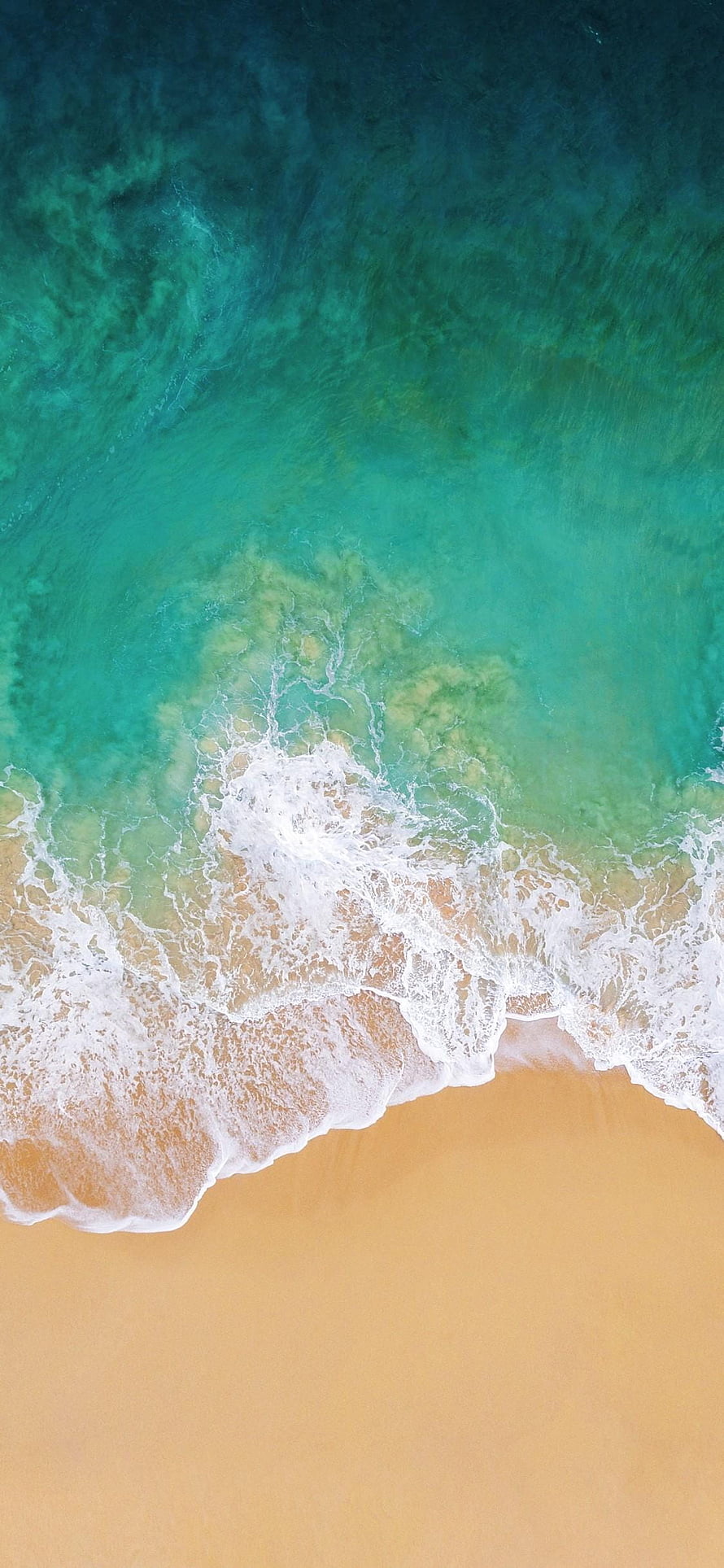 Aerial View of Turquoise Ocean Waves Lapping Against Golden Sand Beach HD phone wallpaper