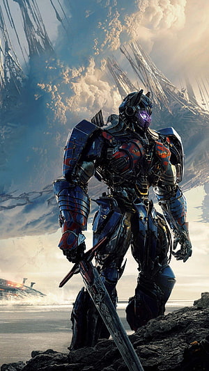 Optimus Prime in Heavy Battle Armor Standing on Rocky Terrain with Giant Sword HD phone wallpaper