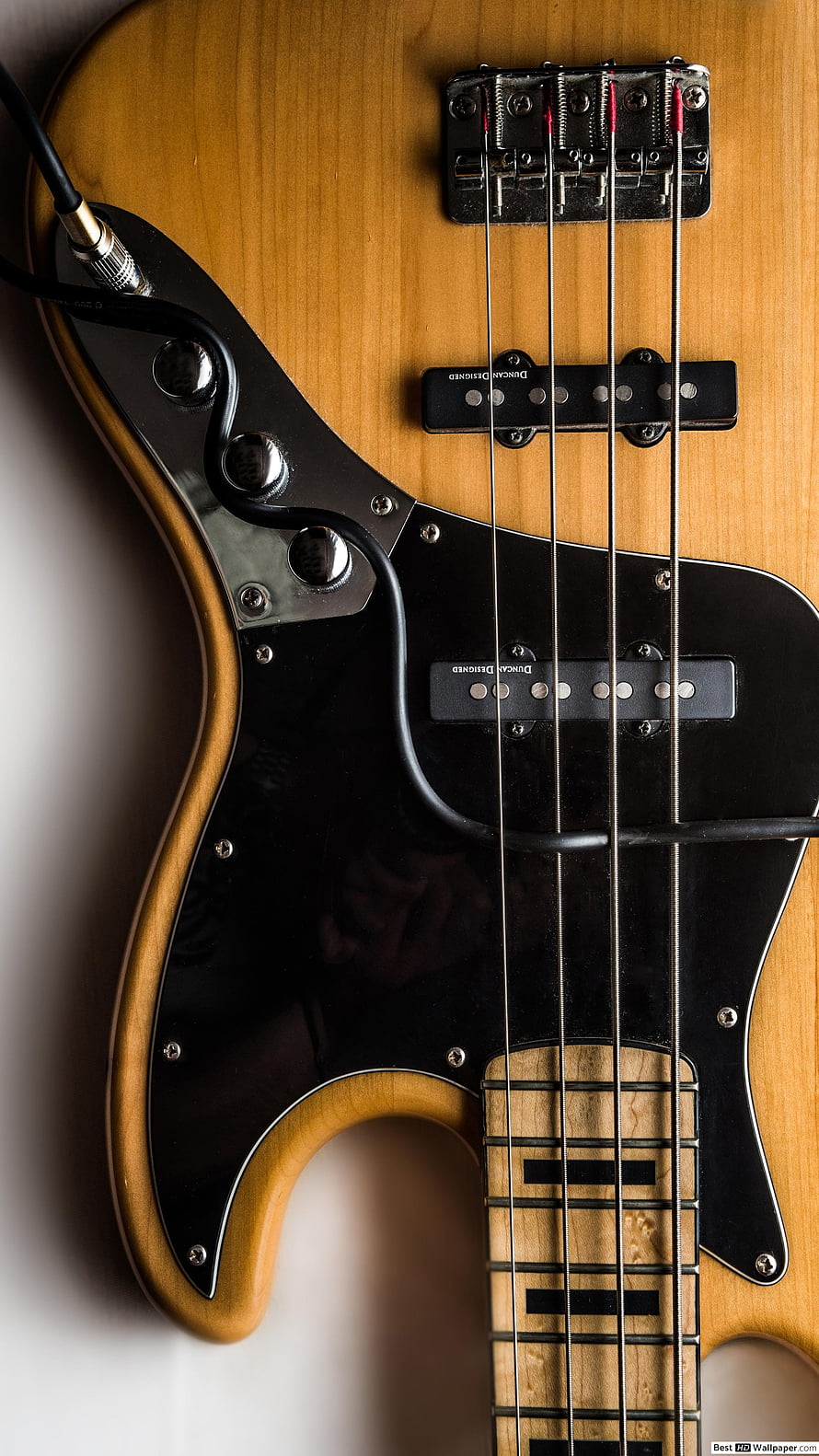 Close-Up of Natural Finish Electric Bass Guitar with Black Pickguard and Strings HD phone wallpaper
