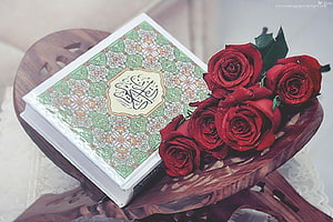 Ornate Quran Book with Red Roses on Carved Wooden Stand HD wallpaper