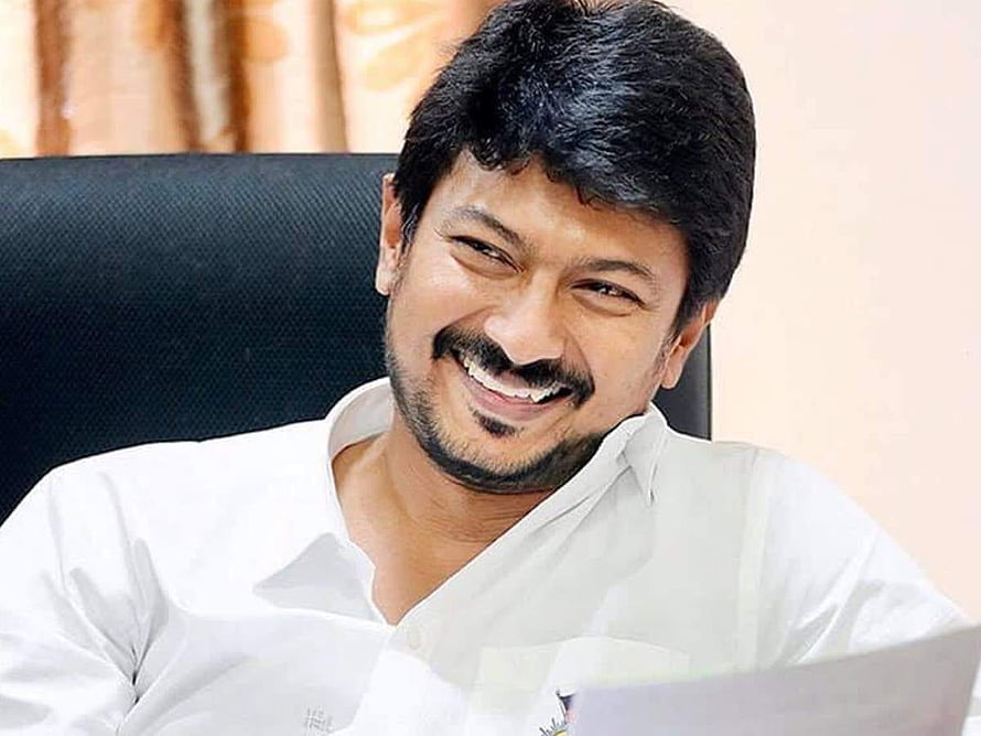 Udhayanidhi Stalin smiling in a white shirt while seated in an office chair HD wallpaper