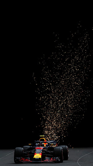 Red Bull Racing Formula 1 car launching sparks on a dark race track at night HD phone wallpaper