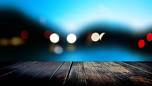 Rustic wooden table surface with blurred city lights and bokeh background HD wallpaper