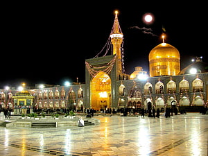 Imam Reza Shrine in Mashhad, Iran, illuminated at night with a full moon and golden dome HD wallpaper