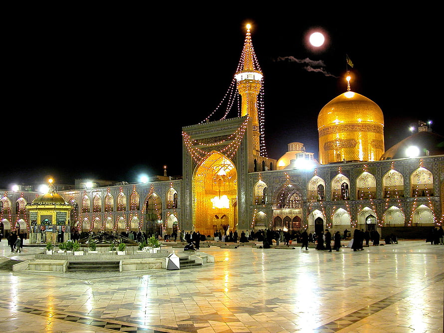 Imam Reza Shrine in Mashhad, Iran, illuminated at night with a full moon and golden dome HD wallpaper