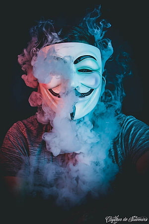 Guy Wearing Guy Fawkes Mask Surrounded by Dramatic Smoke and Neon Lighting HD phone wallpaper