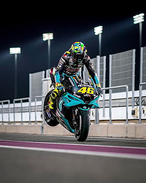 Valentino Rossi riding the Petronas Yamaha YZR-M1 number 46 during a night race HD phone wallpaper
