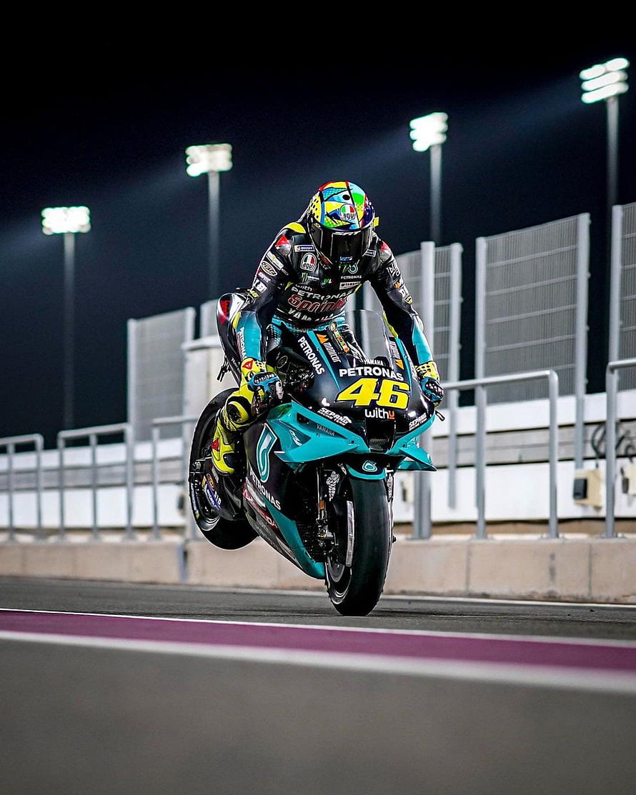 Valentino Rossi riding the Petronas Yamaha YZR-M1 number 46 during a night race HD phone wallpaper
