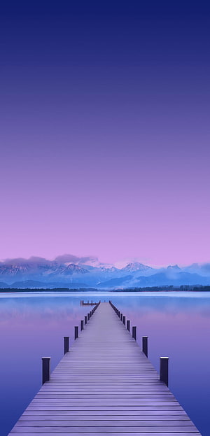 Serene Wooden Pier Extending Into Calm Lake With Distant Snow-Capped Mountains Under a Purple Twilight Sky HD phone wallpaper