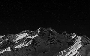 Snow-Capped Alpine Peaks Under a Star-Filled Night Sky HD wallpaper
