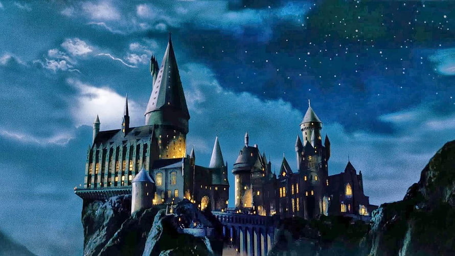 Hogwarts Castle at Night with Glowing Windows and Starry Sky HD wallpaper