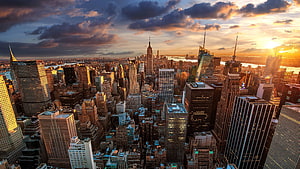 Aerial View of New York City Skyline at Golden Hour with Dramatic Clouds HD wallpaper