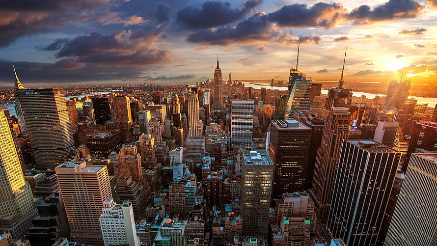 Aerial View of New York City Skyline at Golden Hour with Dramatic Clouds HD wallpaper
