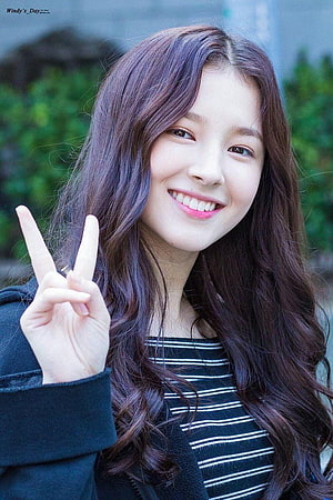 Nancy from Momoland smiling and making a peace sign with long wavy hair HD phone wallpaper