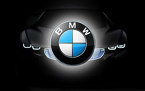 Illuminated BMW Emblem on Sleek Black Car Front with Glowing Headlights HD wallpaper