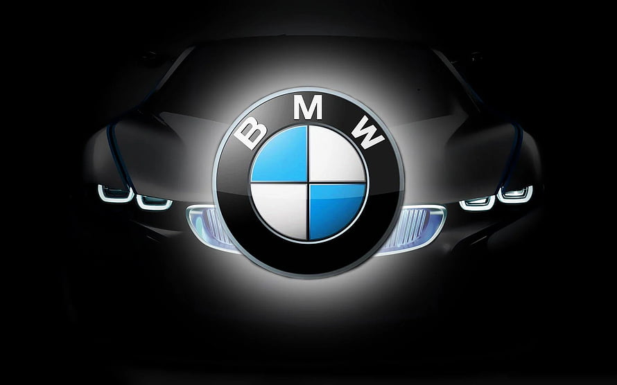 Illuminated BMW Emblem on Sleek Black Car Front with Glowing Headlights HD wallpaper