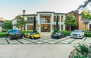 Luxury Mansion Facade With High-End Sports Cars Parked On A Patterned Driveway HD wallpaper