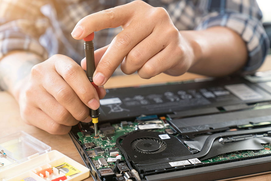 Technician Performing Precision Laptop Repair on Exposed Motherboard HD wallpaper