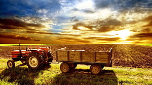 Red Tractor and Wooden Farm Trailer in a Plowed Field at Golden Sunset HD wallpaper